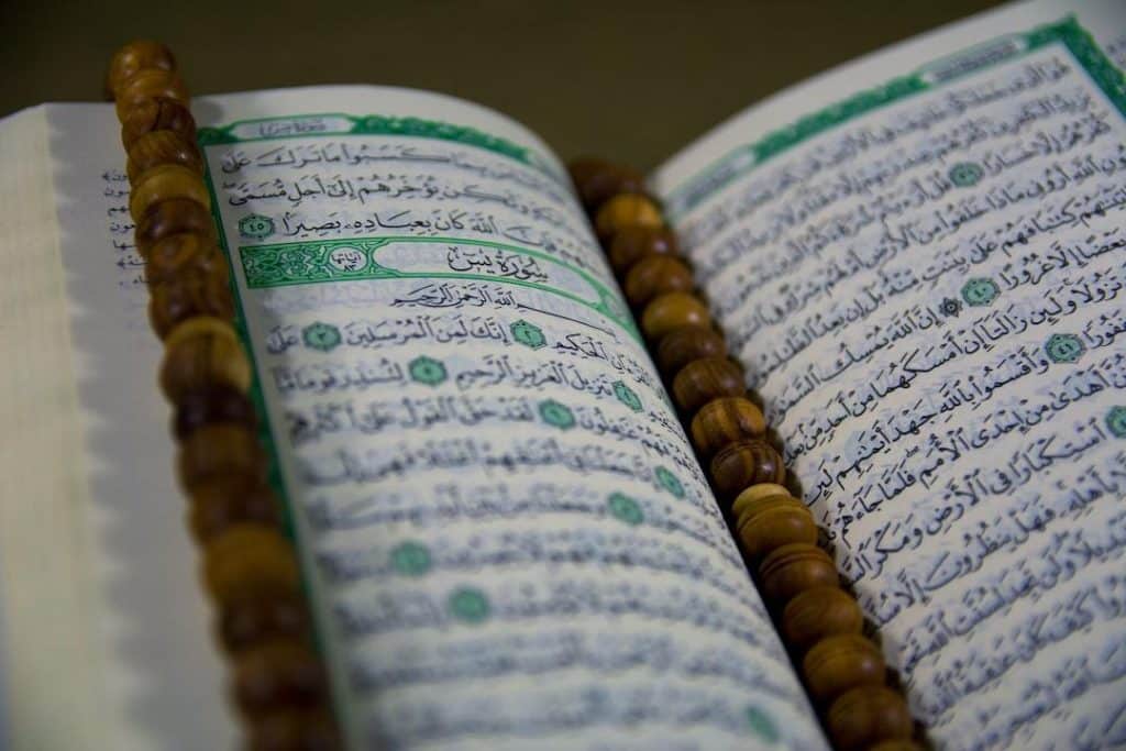 text - Closuep of Muslims Holy Book Quran Majid Closeup of Islamic Book Quran in Arabic Text and a Tasbeeh on it, tags: danmark som svar på - unsplash