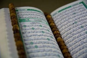 text - Closuep of Muslims Holy Book Quran Majid Closeup of Islamic Book Quran in Arabic Text and a Tasbeeh on it, tags: danmark som svar på - unsplash
